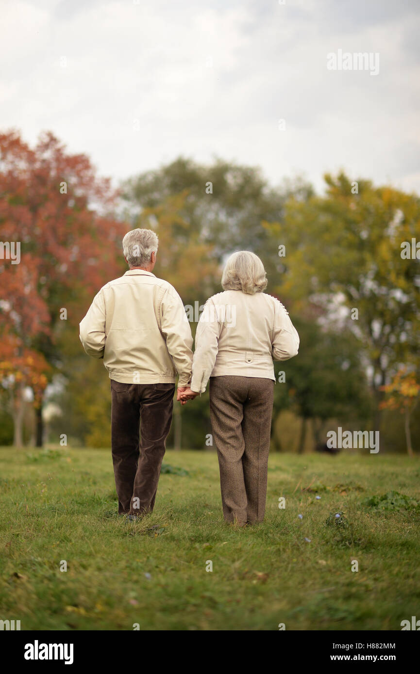 Couple de personnes âgées s'en va par l'allée du parc en automne Banque D'Images