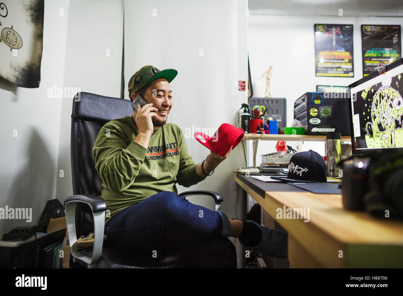 Design Studio. Un homme assis à un bureau de passer un appel téléphonique. Banque D'Images