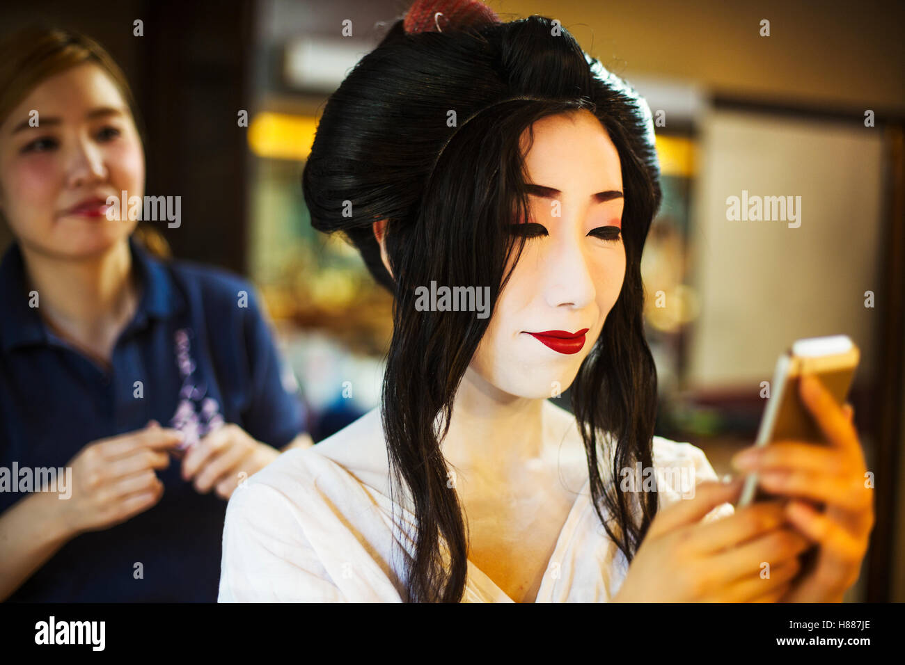 Une geisha ou maiko par un cheveu et composent artiste créant le traditionnel style de cheveux et de maquillage. Banque D'Images