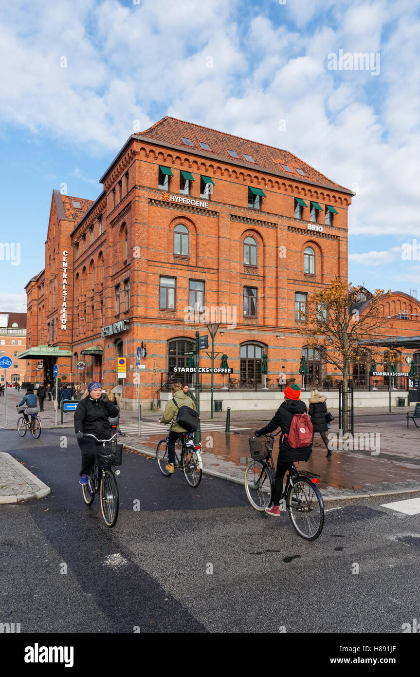 Les cyclistes passant la gare centrale de Malmö, Suède Banque D'Images