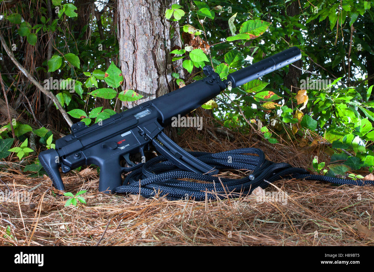 Fusil d'assaut avec un silencieux fixé dans les bois Banque D'Images