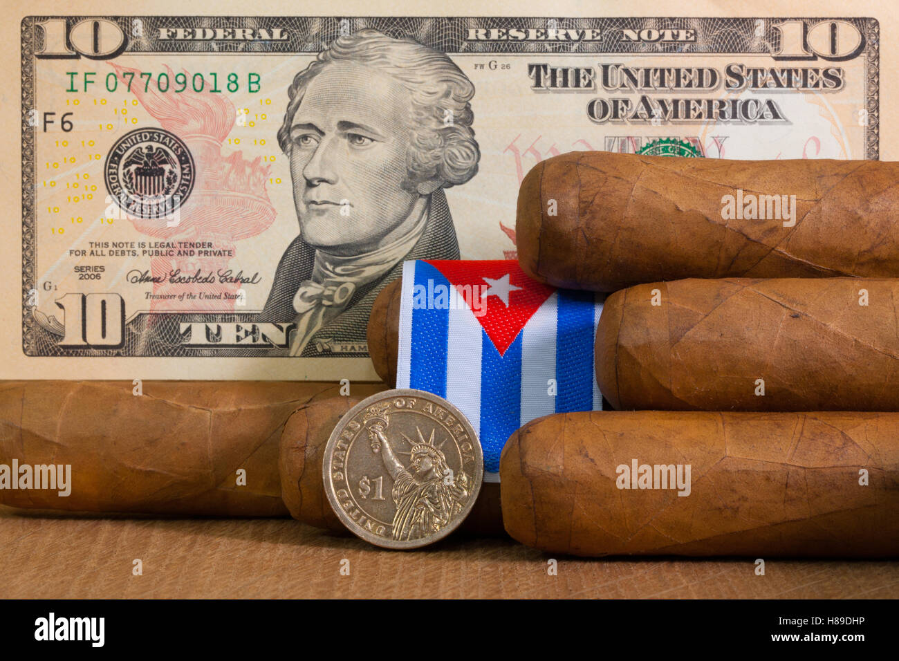 Cigares Cubains de luxe avec des billets et pièces en dollars US sur la table en bois. Banque D'Images