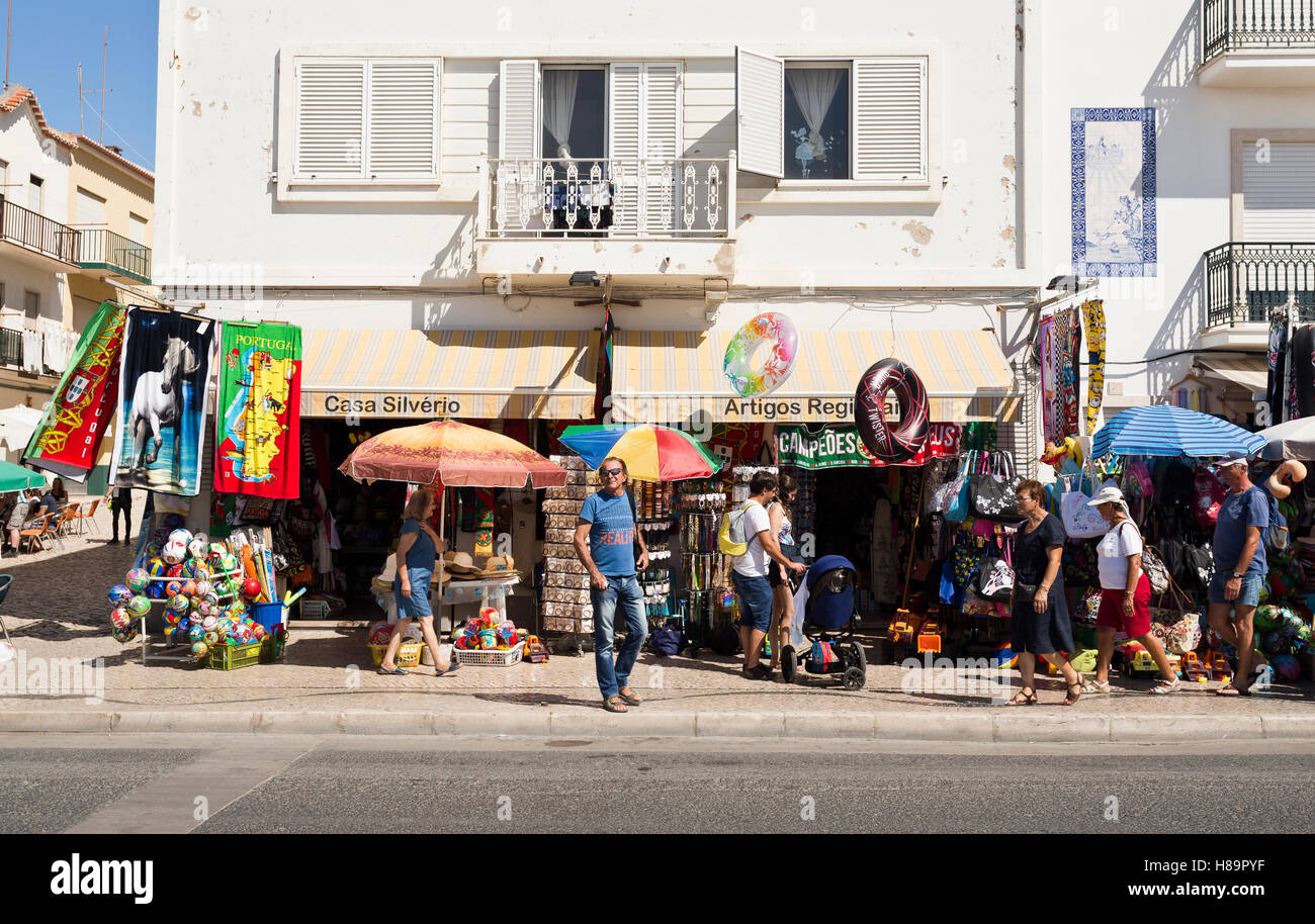 Vue sur les magasins de détail le long de la populaire avenue en bord de mer dans le village de pêcheurs de Nazaré, Portugal Banque D'Images