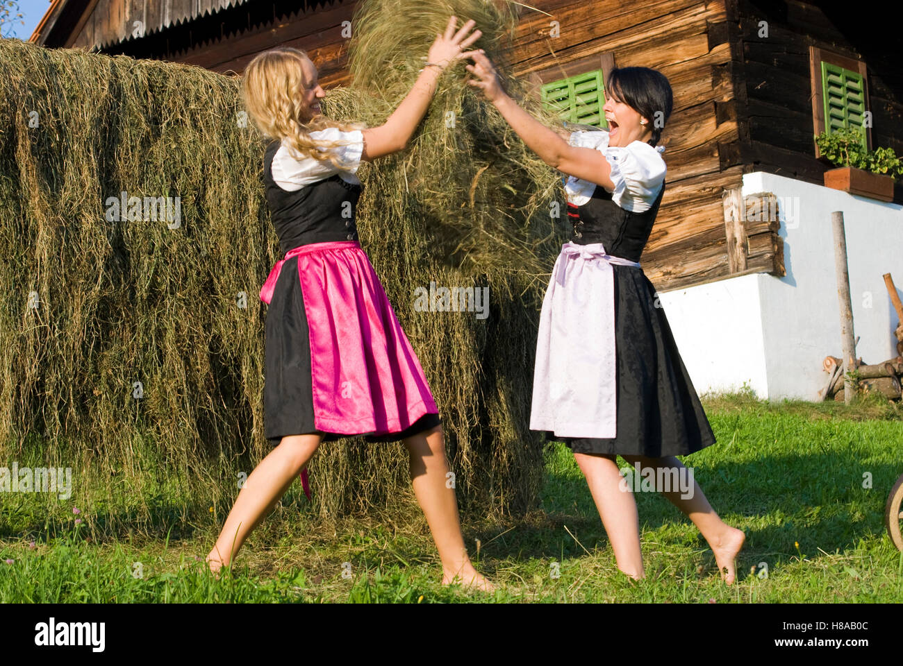 Jeune femme portant deux robes Dirndl foin récolte Banque D'Images