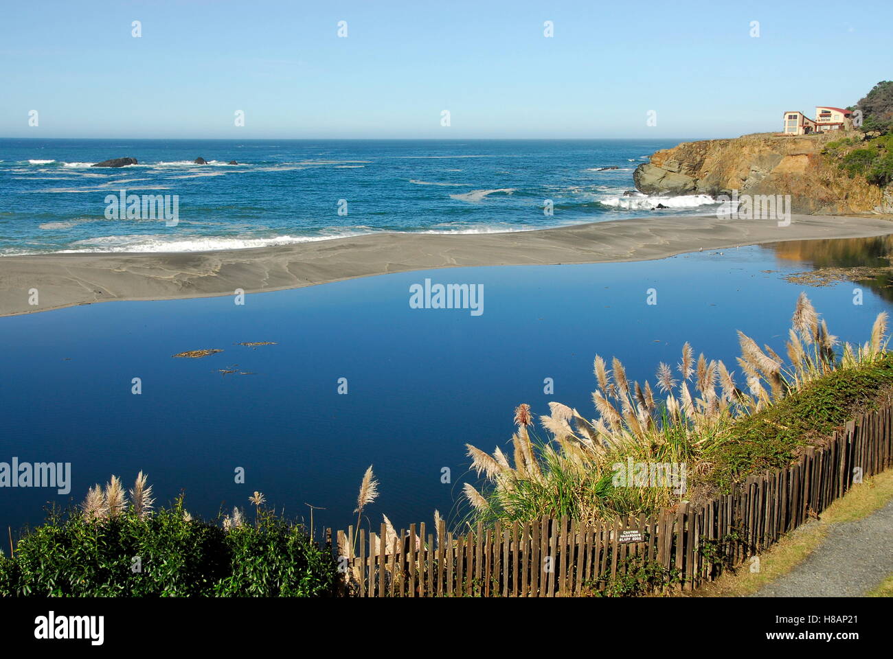 Banc de sable et embouchure de la rivière coulant Athens dans l'océan Pacifique. L'herbe de la pampa en croissance sur des falaises sur le sentier Bluff Banque D'Images