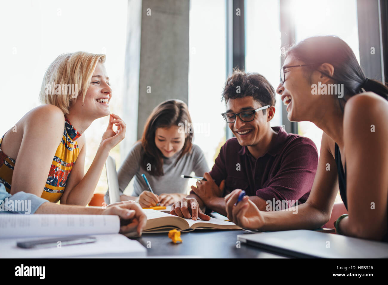 Les jeunes multiethniques sitting at table lecture Livres de référence pour l'étude des notes. Groupe de professionnels jeunes étudiants en coopération Banque D'Images