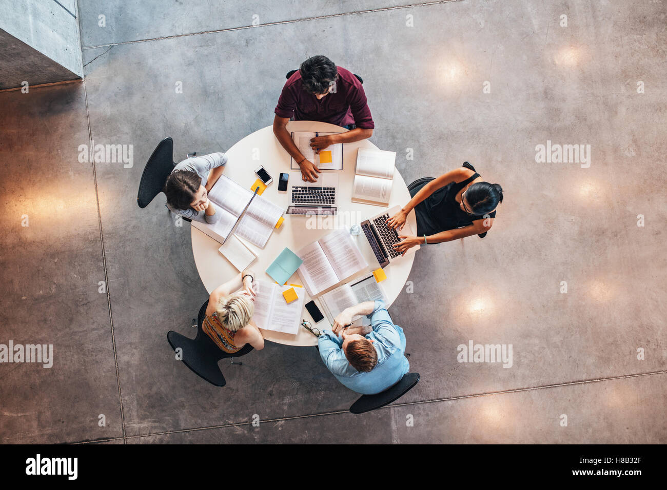 Groupe de jeunes étudiants en coopération avec leur établissement d'affectation. Vue d'en haut photo de jeunes qui étudient ensemble autour d'un Banque D'Images