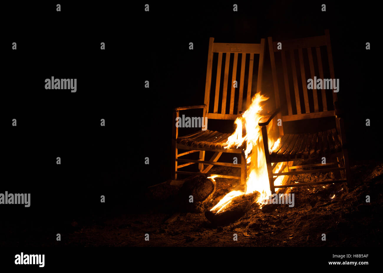Le feu qui brûle sur une paire de vieilles chaises à bascule Banque D'Images