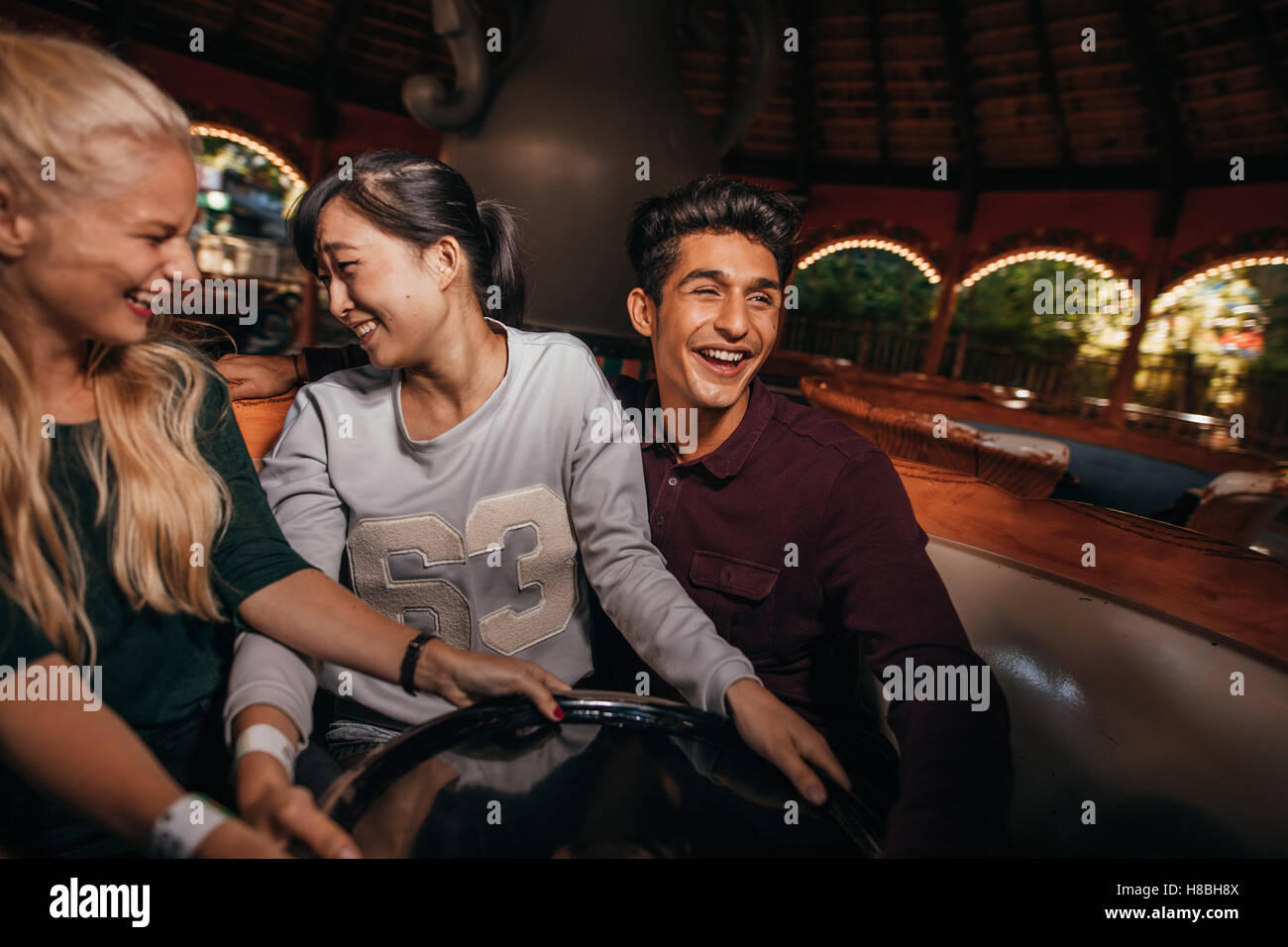 Les jeunes enthousiastes jouissant d'une ride at amusement park. Les jeunes s'amuser au parc d'amusement. Banque D'Images