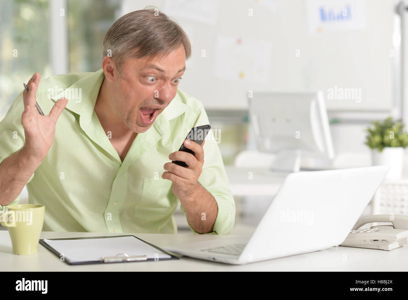 Stressed businessman with smartphone Banque D'Images