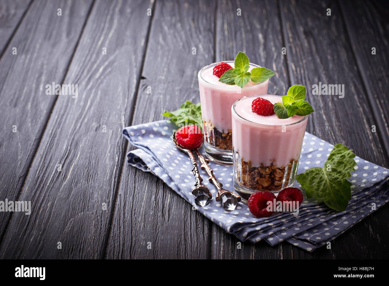 Dessert avec le muesli, yaourt et framboises. Selective focus Banque D'Images