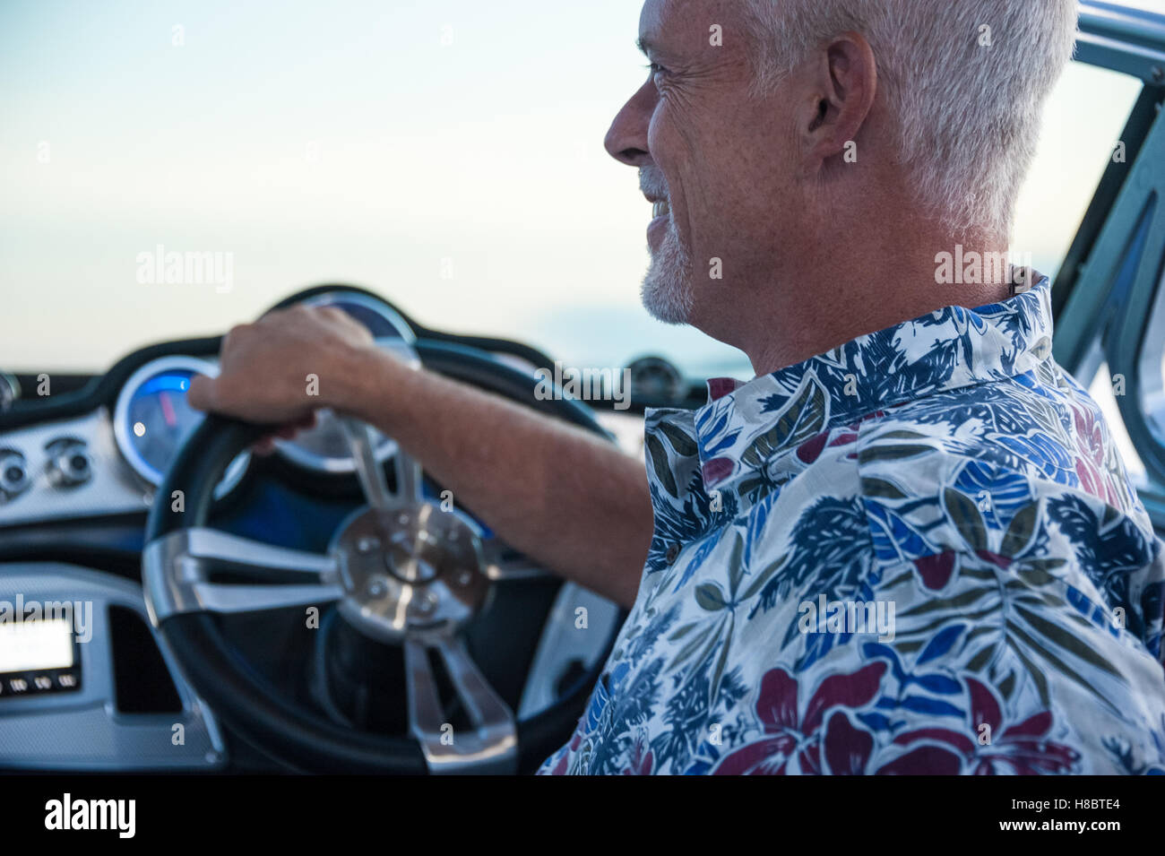 Man bénéficiant d'une soirée sur le lac dans son bateau Mastercraft service surf. Banque D'Images