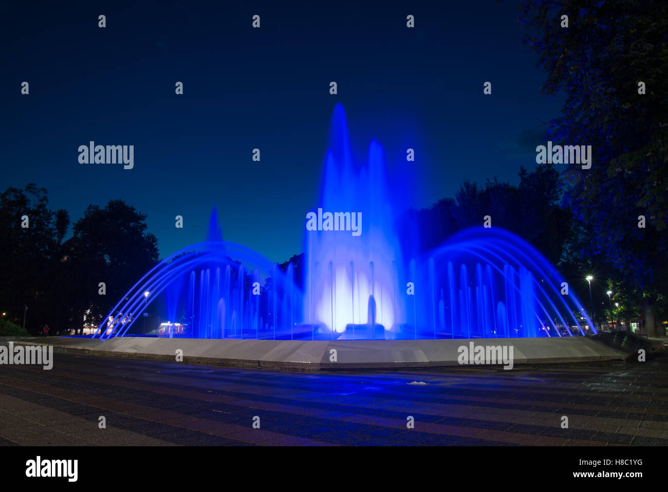 Une fontaine d'eau éclairé par des lumières bleues dans la nuit Banque D'Images