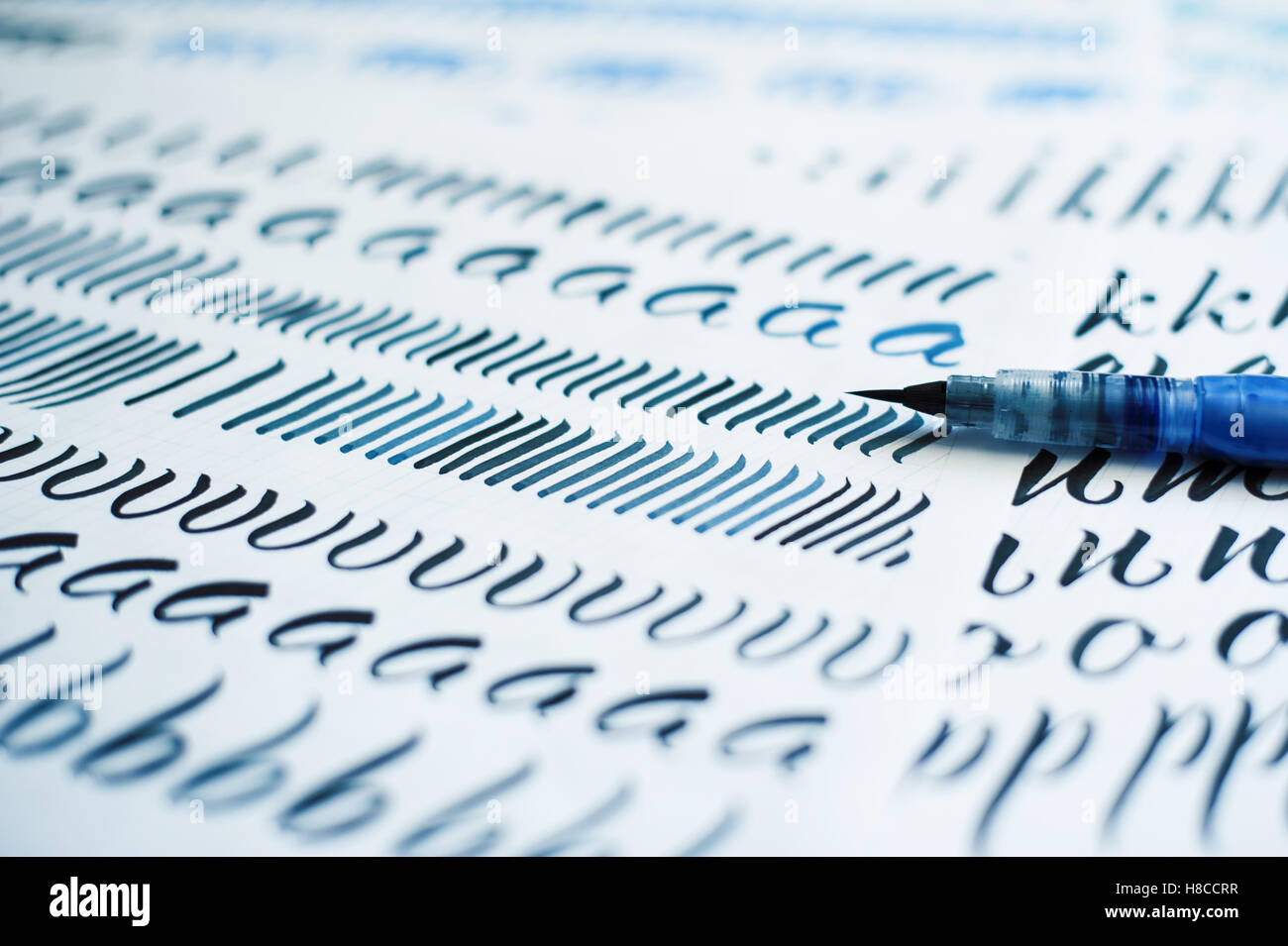 Feuille de papier avec des lettres et pinceau pour la calligraphie Banque D'Images