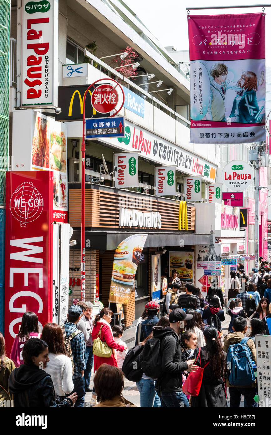 Japon, Tokyo, Harajuku. Afficher le long de la rue piétonnière Takeshita de monde à la mi-journée, bordée par McDonalds et petites boutiques de mode et magasins. Banque D'Images