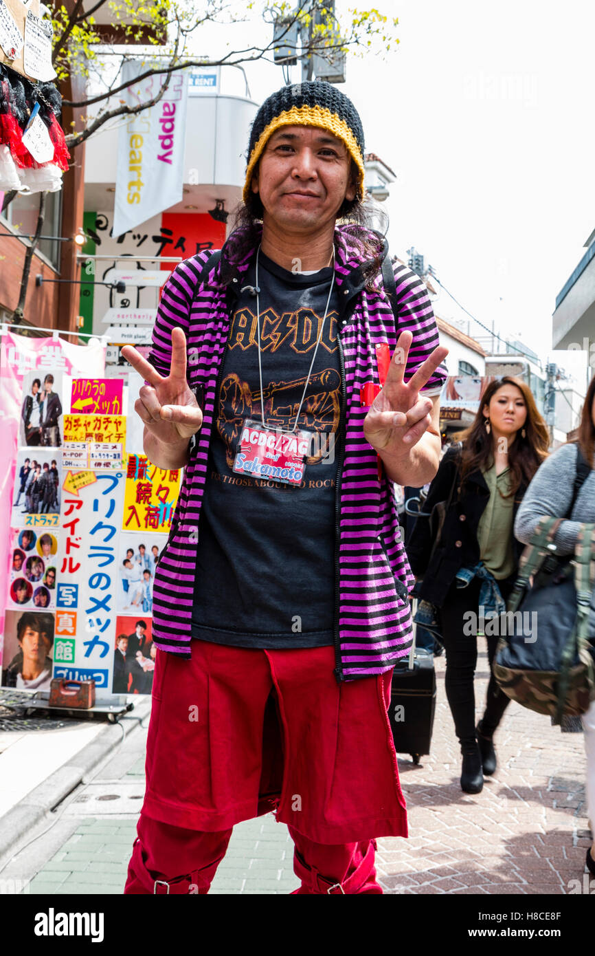 Japon, Tokyo, Harajuku, Takeshita-dori. ACDC Rag, gothique lolita store assistant, homme, posant en face d'événements, contact avec les yeux, les deux mains dans un geste de paix. Banque D'Images