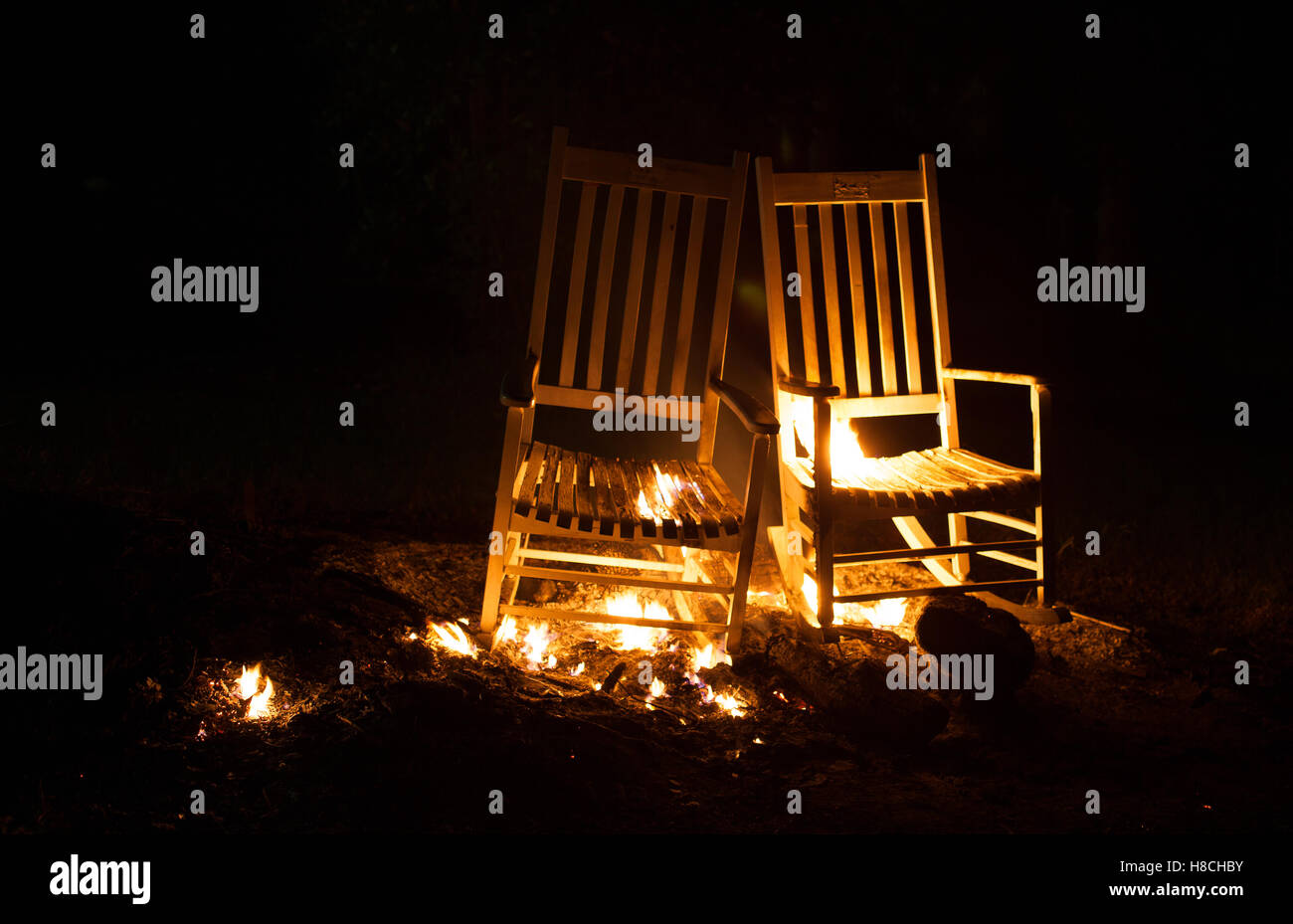Des chaises à bascule qui ont la fumée et des flammes sur eux Banque D'Images