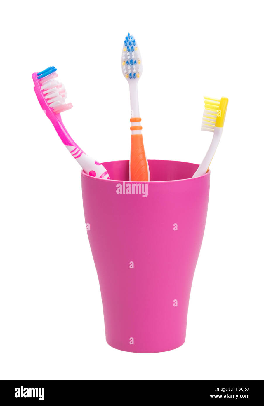 Verre violet avec trois brosses à dents.une famille. isolé sur fond blanc Banque D'Images