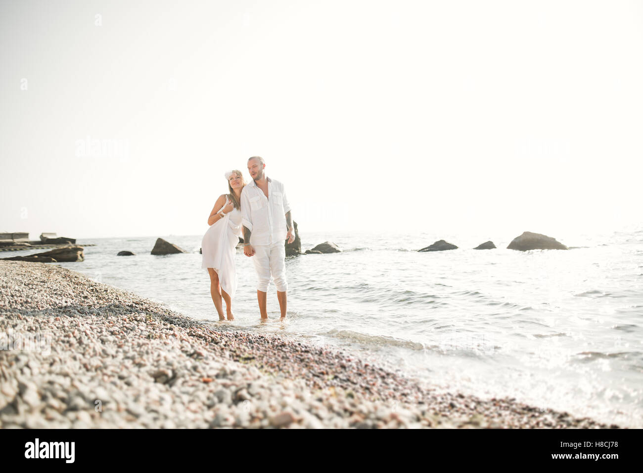Les jeunes mariés heureux juste couples célébrant de mariage et vous amuser au belle plage coucher du soleil Banque D'Images