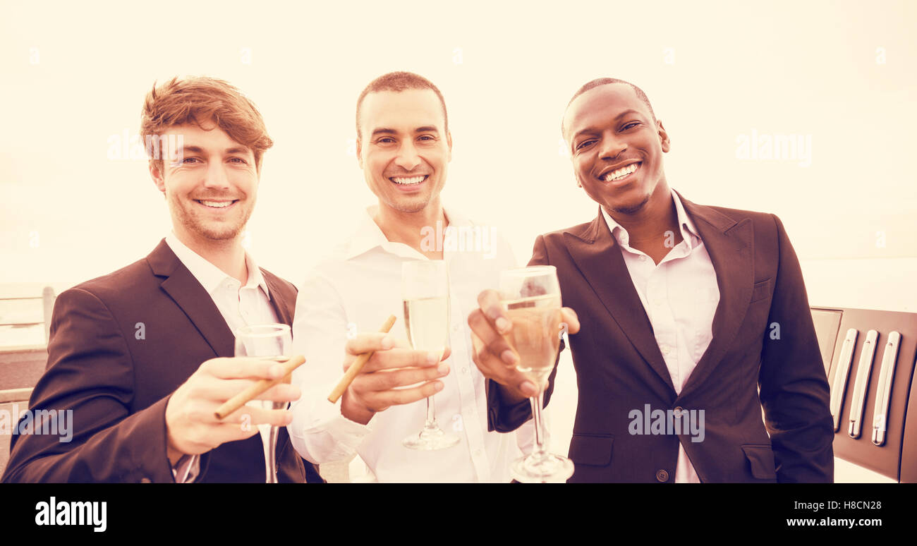 Portrait des hommes bien habillés de boire du champagne à côté de limousine Banque D'Images