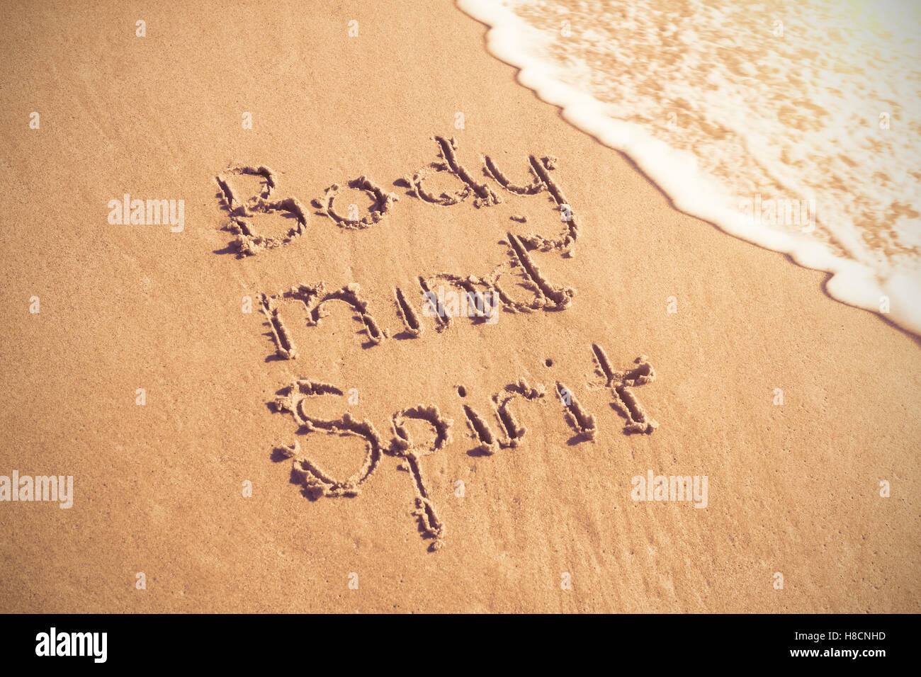 Body mind spirit texte écrit sur le sable avec surf Banque D'Images