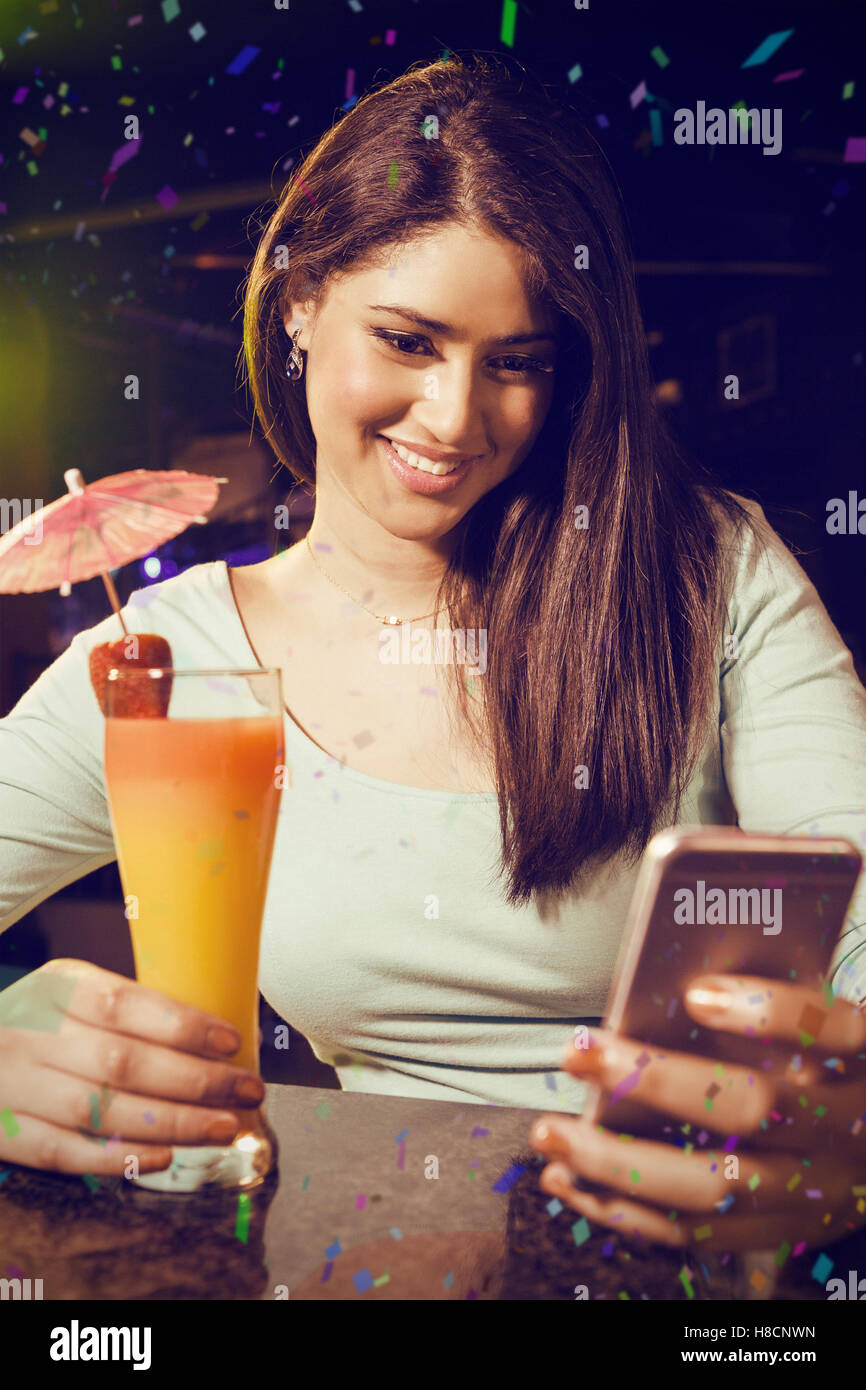 Image composite de belle femme saisie de texte message tandis que having cocktail Banque D'Images