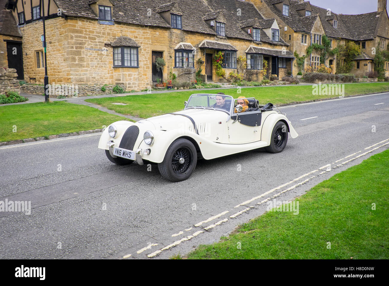 Voiture classique blanc sur la route du village appelé broadway à cotswold, Angleterre Banque D'Images