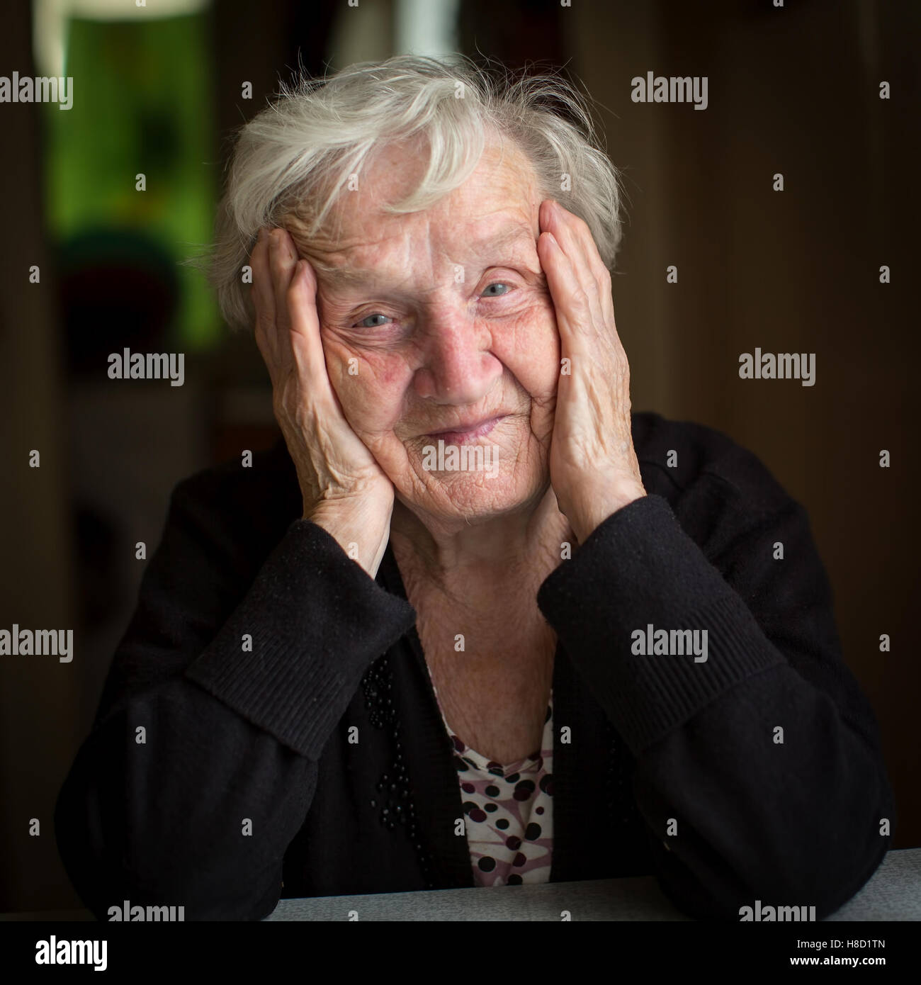 Grand-mère russe. Portrait d'une femme âgée assise à une table dans sa chambre. Banque D'Images