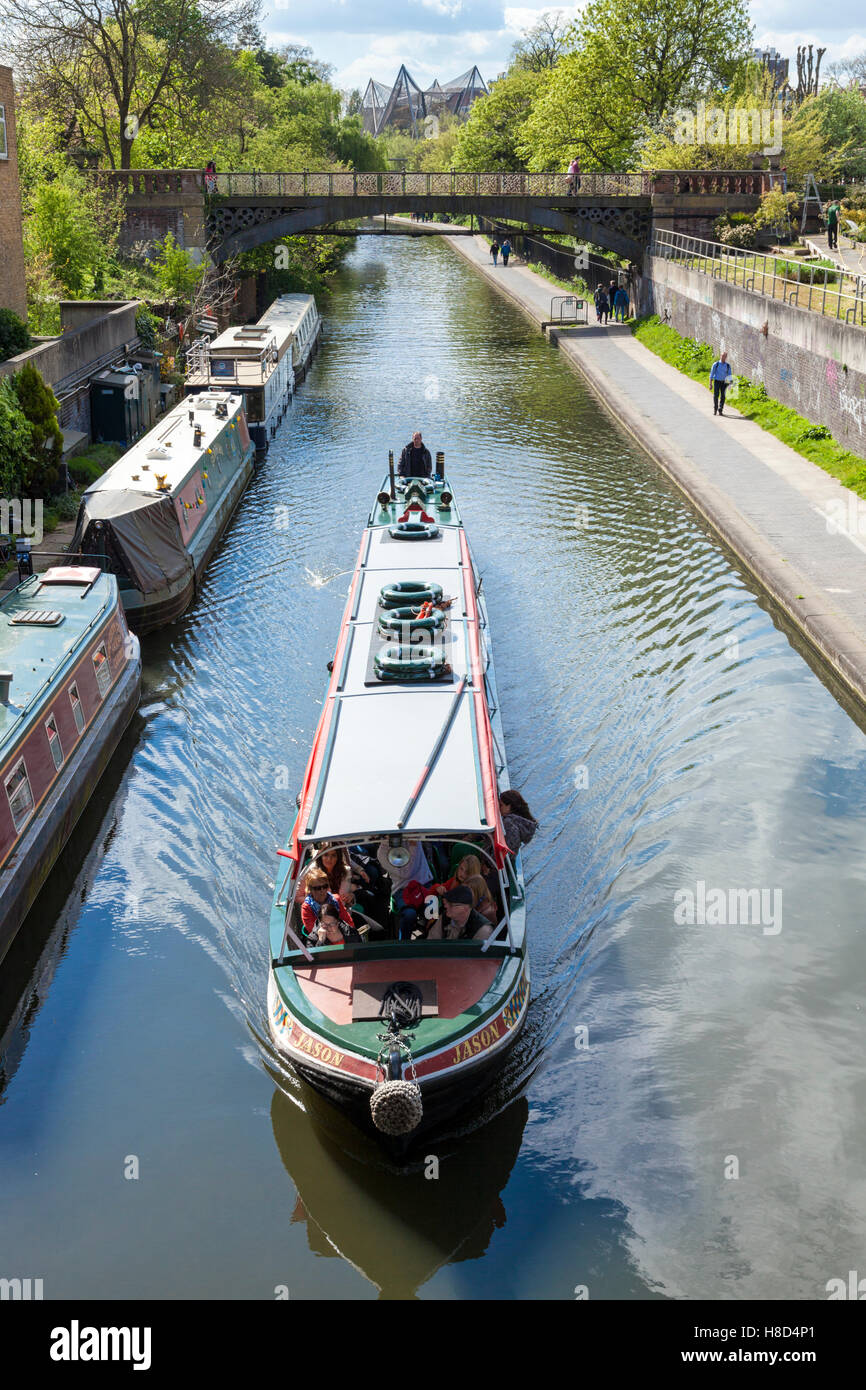 Les touristes en bateau sur un canal passant mouillée narrowboats sur Regent's Canal, London, England, UK Banque D'Images