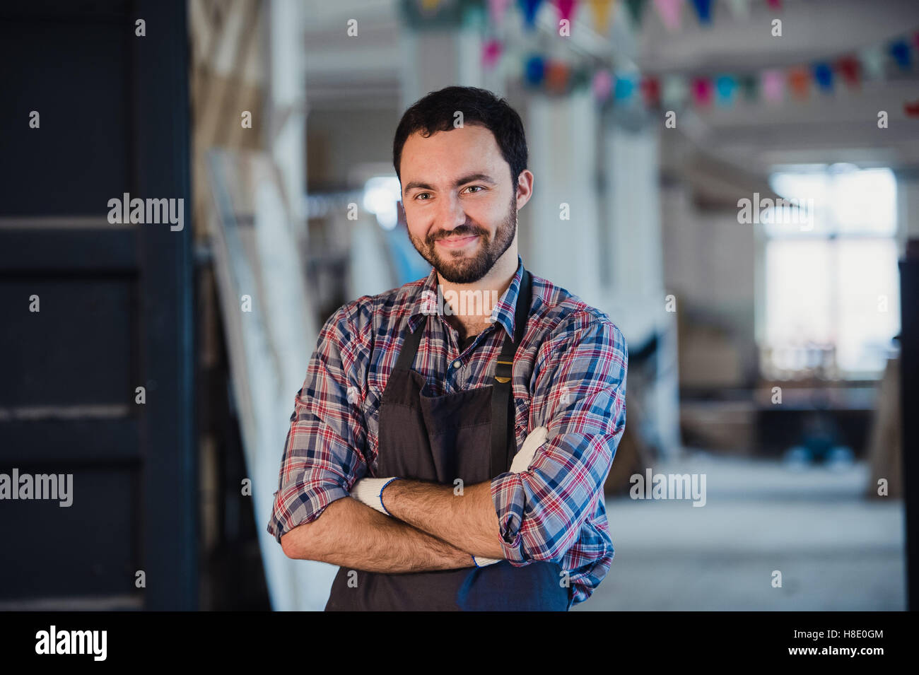 Atelier est mon monde. Young male carpenter en gardant les bras croisés Banque D'Images