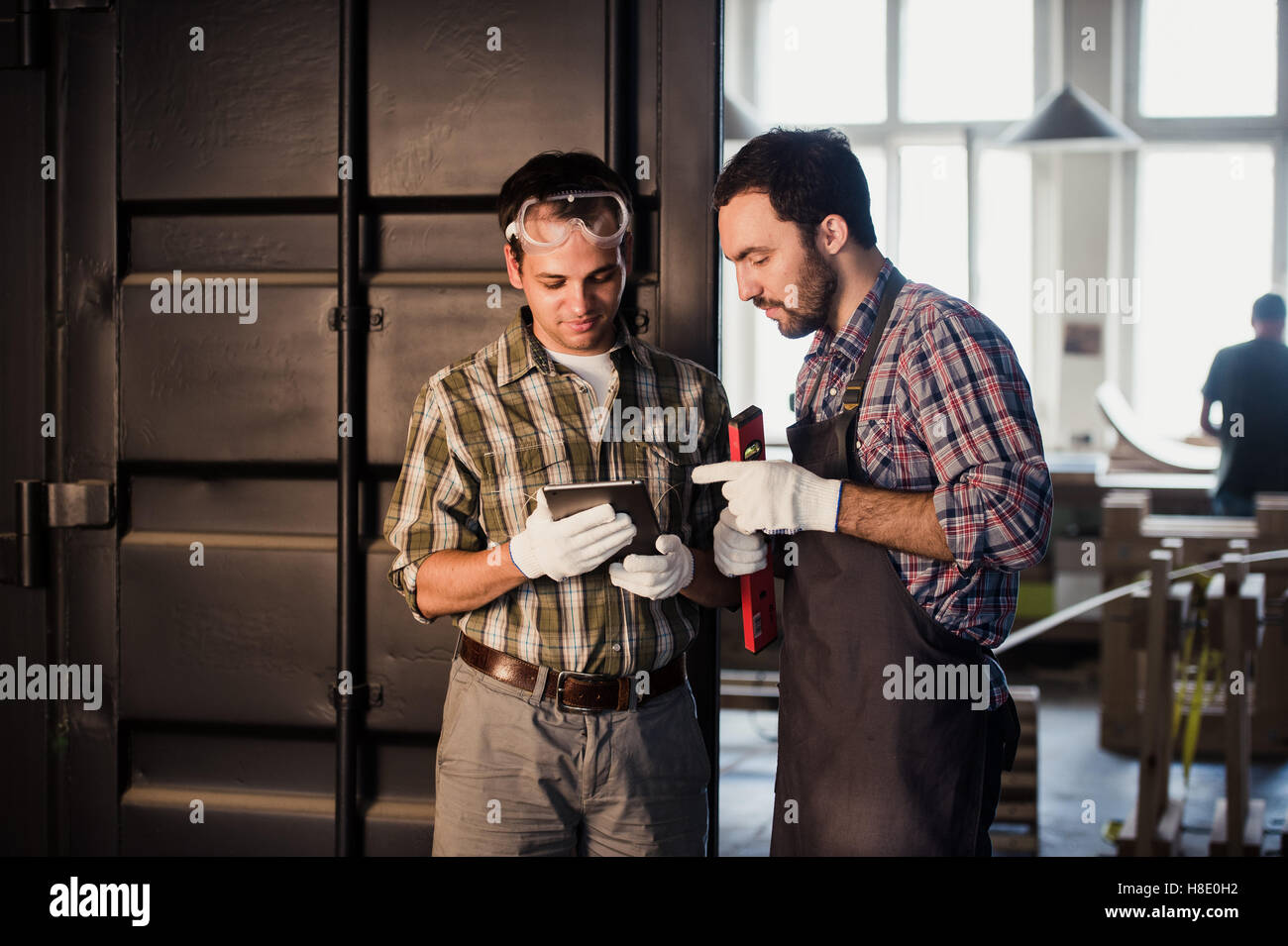 Profession, les hommes et la technologie concept - deux ouvriers avec tablette PC ordinateur en atelier Banque D'Images