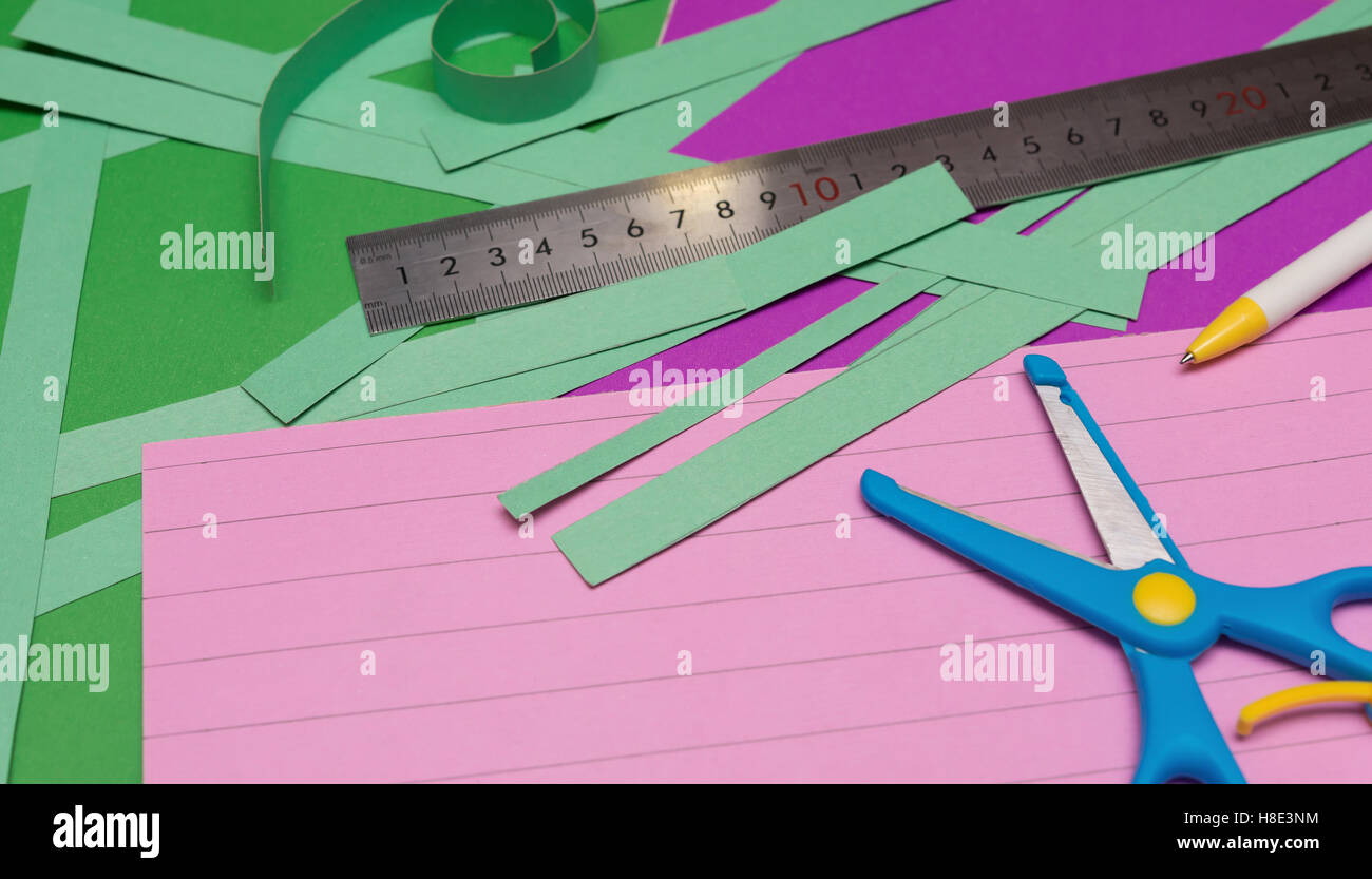 Une règle et des ciseaux et de couper le papier à main sangles sur album coloré Banque D'Images