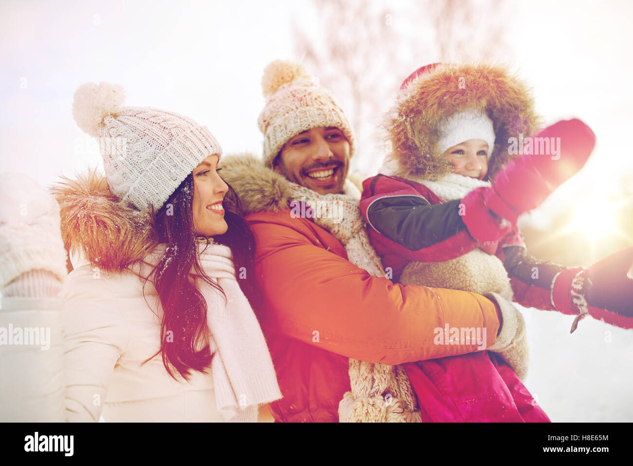 Famille heureuse avec l'enfant dans les vêtements d'hiver en plein air Banque D'Images
