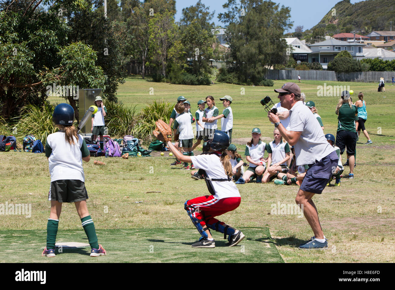 L'école de filles en Australie les enfants jouent au base-ball balle molle sur une zone de parc de Sydney, Australie Banque D'Images