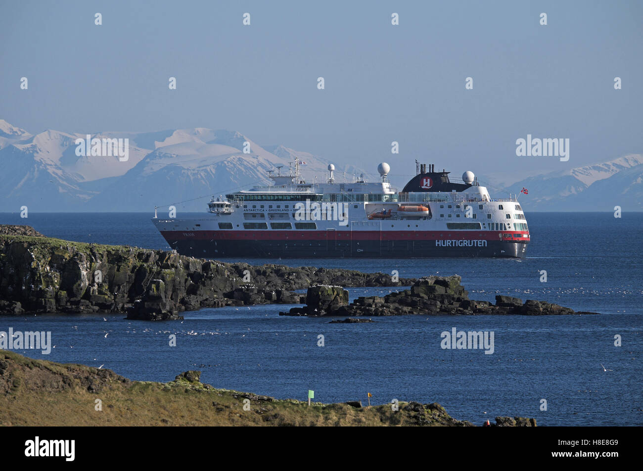 Bateau de croisière arctique M V Fram, avec des montagnes enneigées de la terre ferme au-delà, amarré au large de l'île de Grimsey, N.E. L'Islande. Banque D'Images