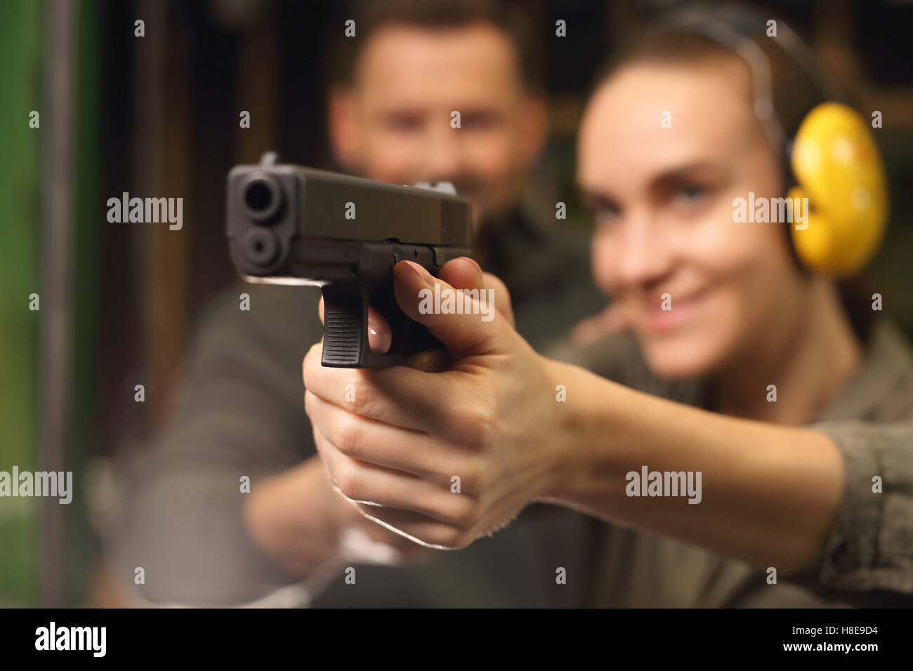 Femme prend des leçons de tir avec une arme de poing sur le champ de tir Banque D'Images