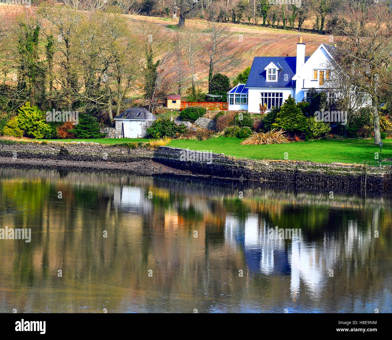 Maison de campagne ou maison riveraine sur la rive d'une rivière, Cork, Irlande. Banque D'Images