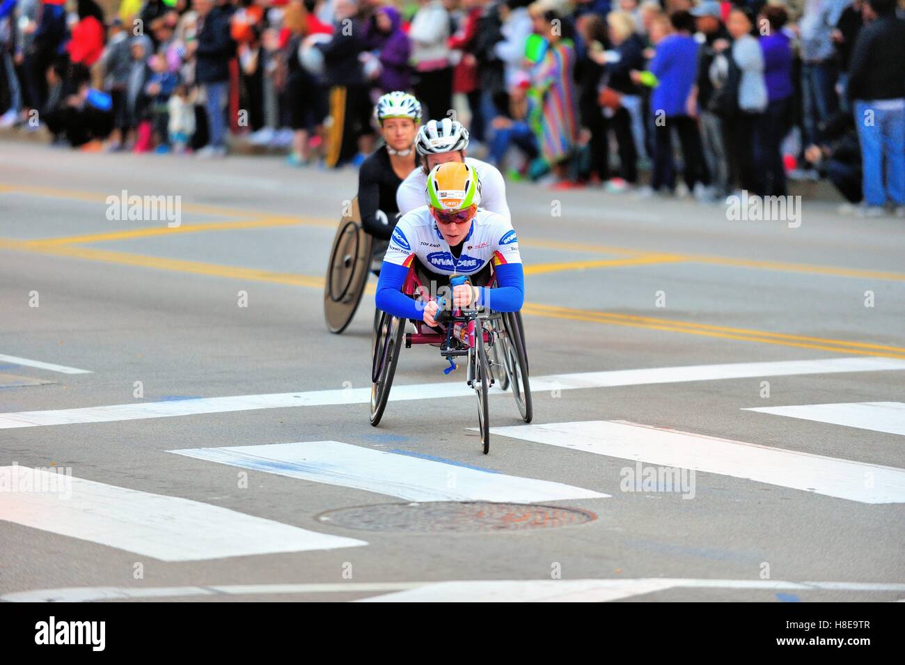 Athlète en fauteuil roulant américaine Amanda Mcgrory conduisant un trio d'athlètes à travers un tour au cours de la 2016 Marathon de Chicago. USA. Banque D'Images