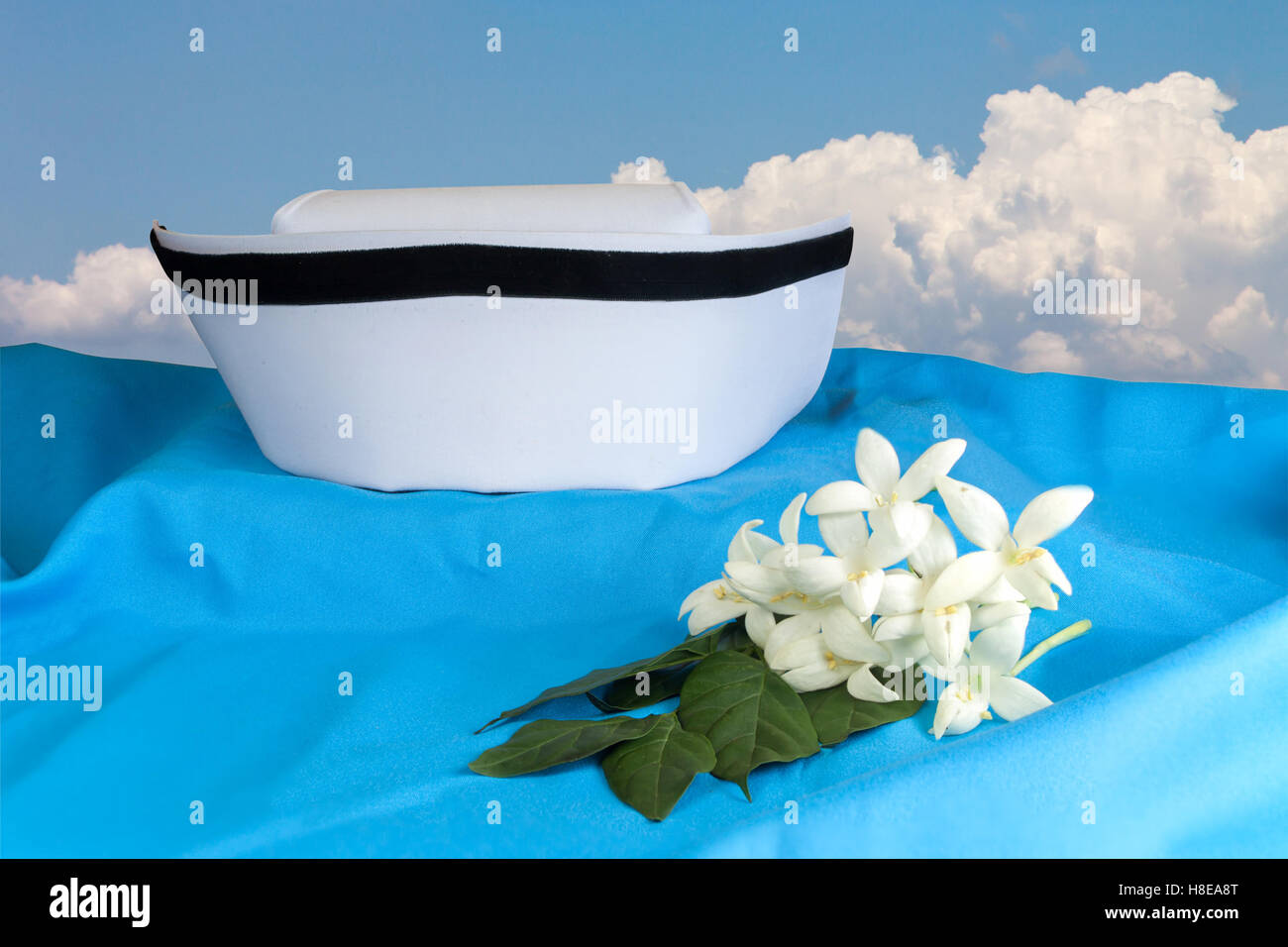 Hat blanc infirmière et Millingtonia hortensis fleurs sur tissu bleu. symbole de la Thaïlande en soins infirmiers et la médecine traditionnelle thaïlandaise. Obj Banque D'Images