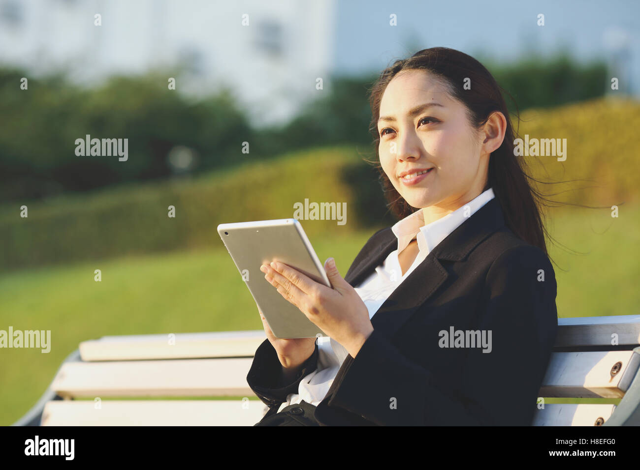 Young Japanese businesswoman with tablet par une rivière centre de Tokyo Banque D'Images