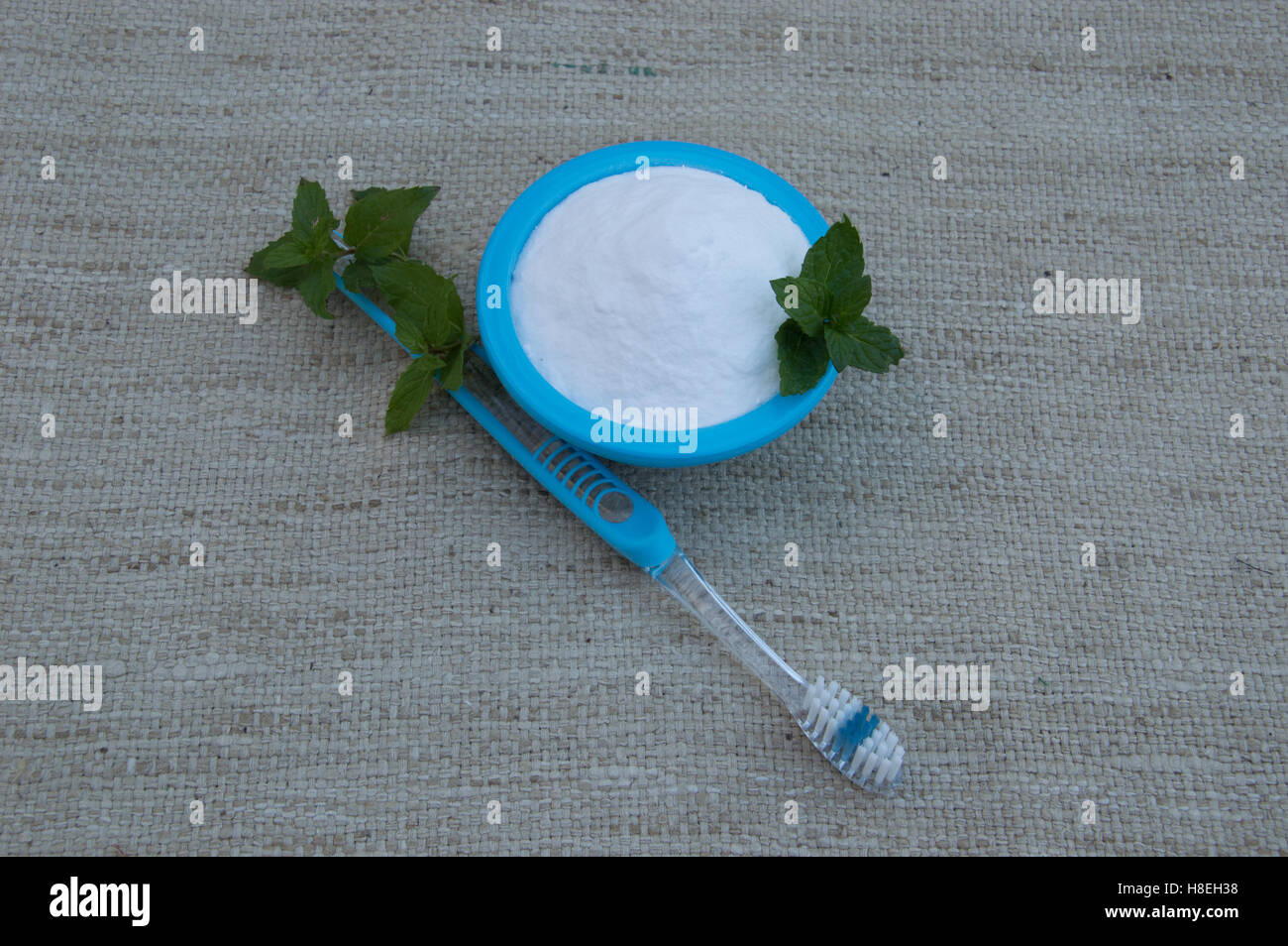 Brosse à dents turquoise et le bol avec du bicarbonate de soude avec de la menthe fraîche pour les produits de blanchiment dentaire et haleine fraîche à partir de ci-dessus. Banque D'Images