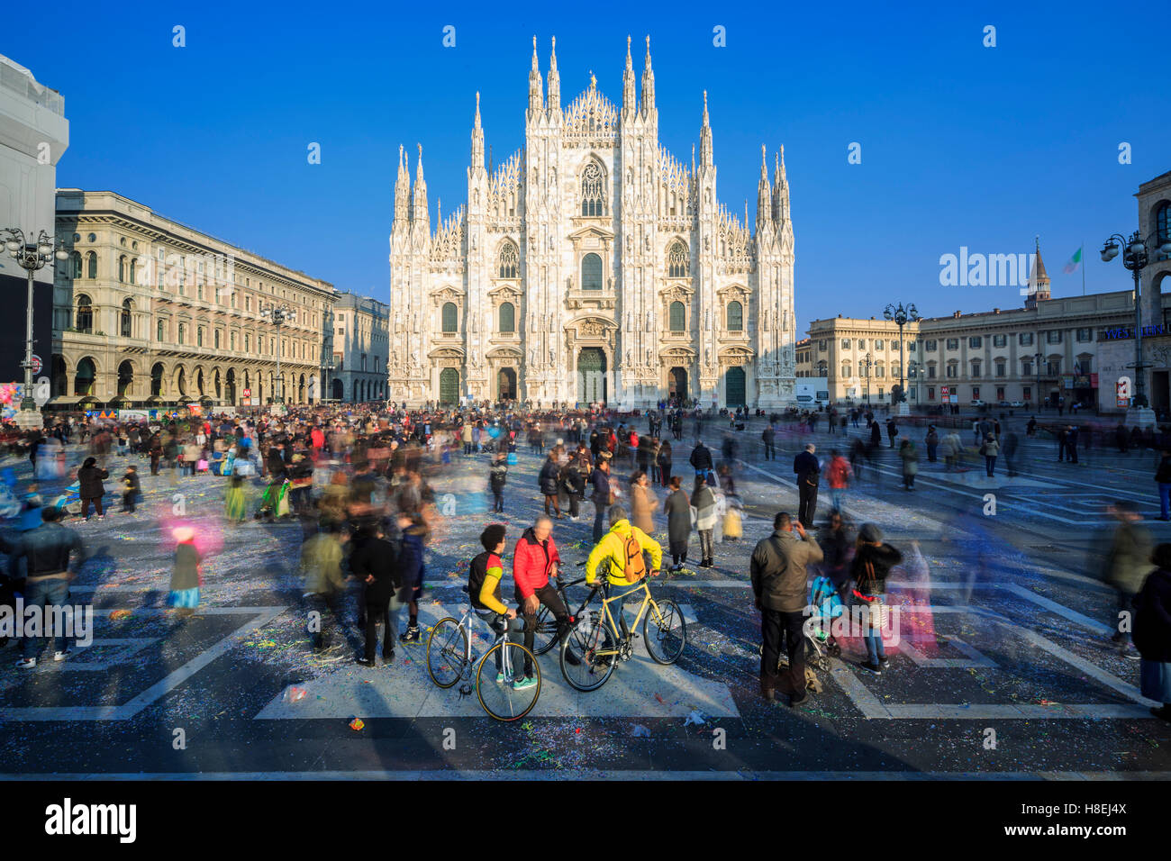 Les cyclistes au printemps chaud soleil en face de la façade de la cathédrale gothique, Milan, Lombardie, Italie, Europe Banque D'Images