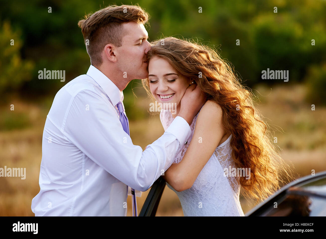 Groom kissing bride dans la tête au mariage à pied Banque D'Images