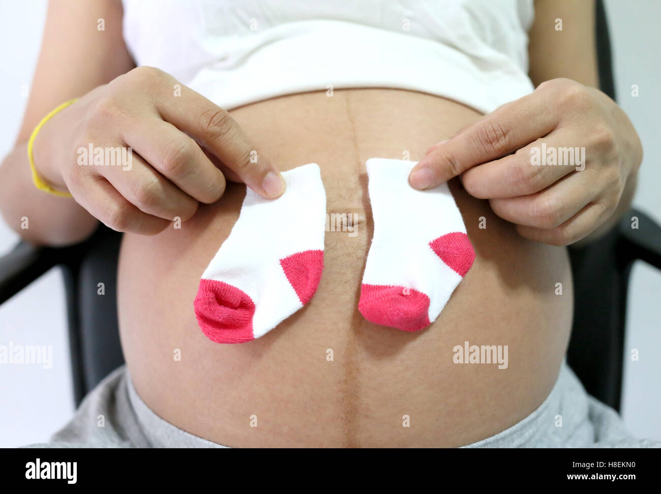 Les femmes enceintes garder sock mis sur ventre concept d'amour pour le bébé. Banque D'Images