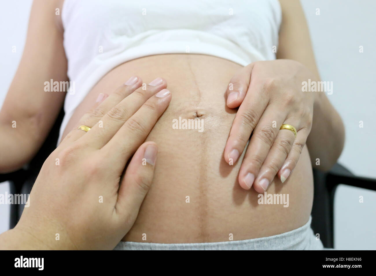 Les femmes enceintes la main et mari main sur ventre concept d'amour pour le bébé. Banque D'Images