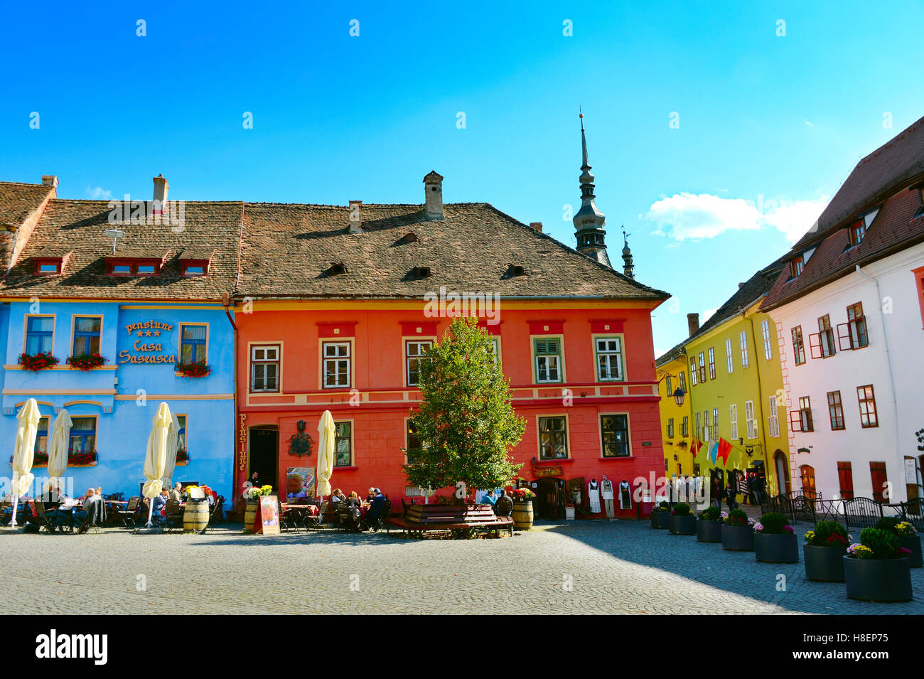Les gens au restaurant dans la vieille ville de Sighisoara. Tour de l'horloge sur l'arrière-plan. Roumanie Banque D'Images