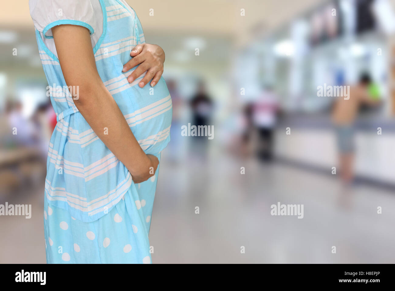 Les femmes enceintes bleu usure des vêtements de maternité à l'hôpital. arrière-plan flou Banque D'Images