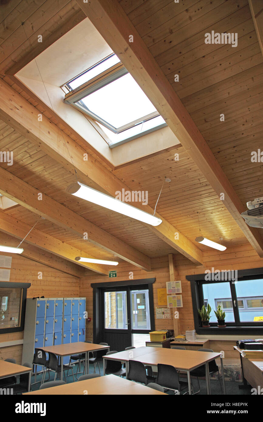 L'intérieur de classe dans une nouvelle école britannique bâtiment construit à partir de bois. Plafond montre et fenêtres de toit. Banque D'Images