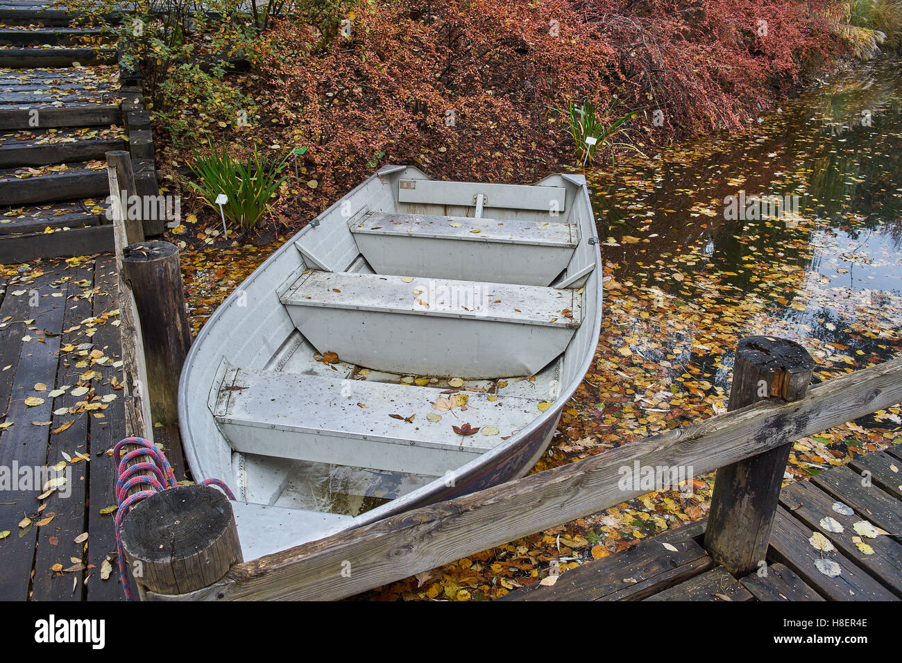 Le silence de l'automne les feuilles tombées de l'eau calme bateau ancré Banque D'Images