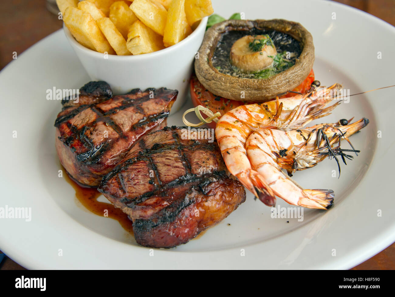 Surf & Turf, steak servi avec des chips de crevettes, champignons et fruits de mer des aliments au Royaume-Uni. Banque D'Images